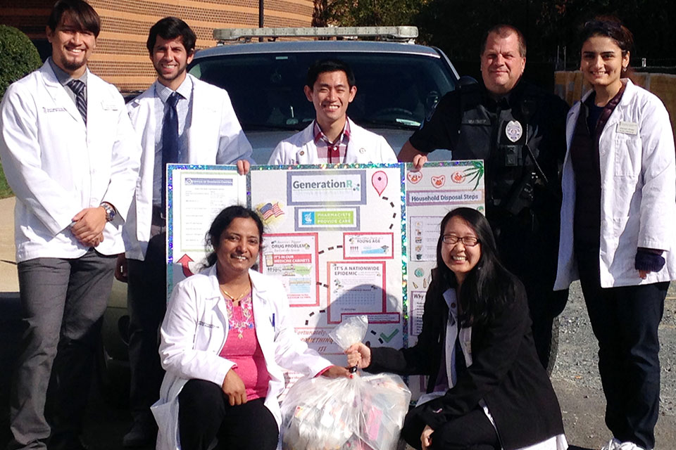 Shady Grove Student Pharmacists Pose with Rockville Police Officer on Drug Take-Back Day