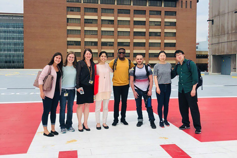 Student pharmacists pose for photo with Dr. Agnes Ann Feemster on the UMMC helipad.