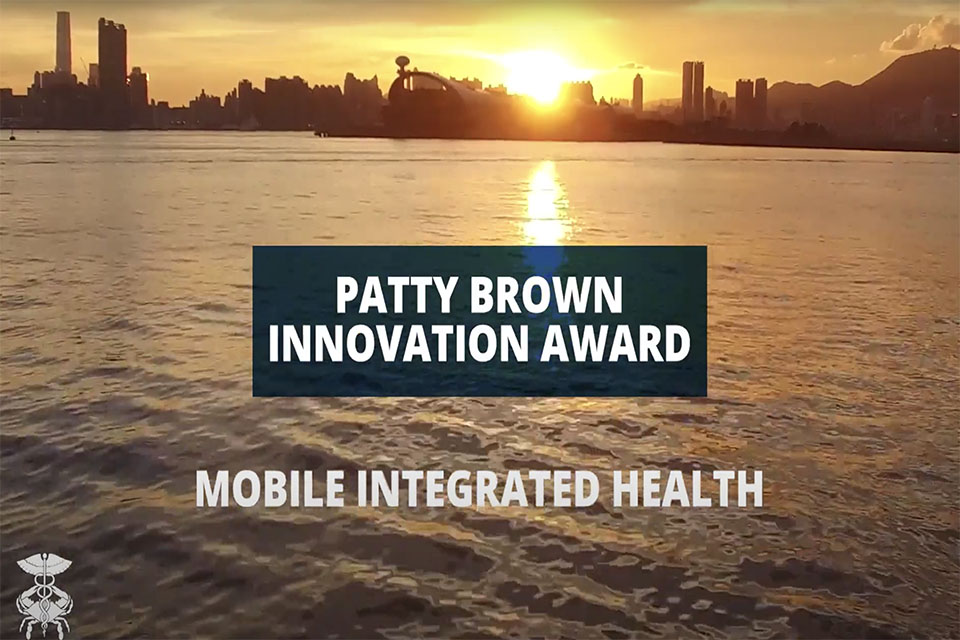 City backdrop with blue box in foreground that read, "Patty Brown Innovation Award." In white text below the box reads, "Mobile Integrated Health."