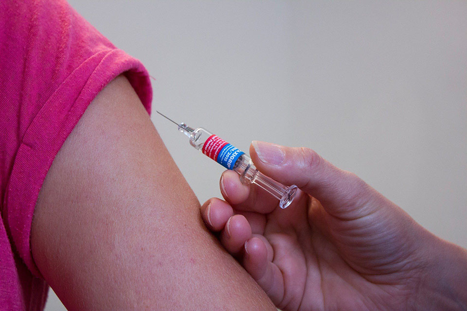 Health care provider administers vaccine to child's arm.