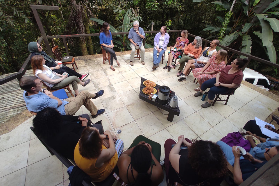The faculty group sitting in a circle listening to Dr. Pablo Oritz