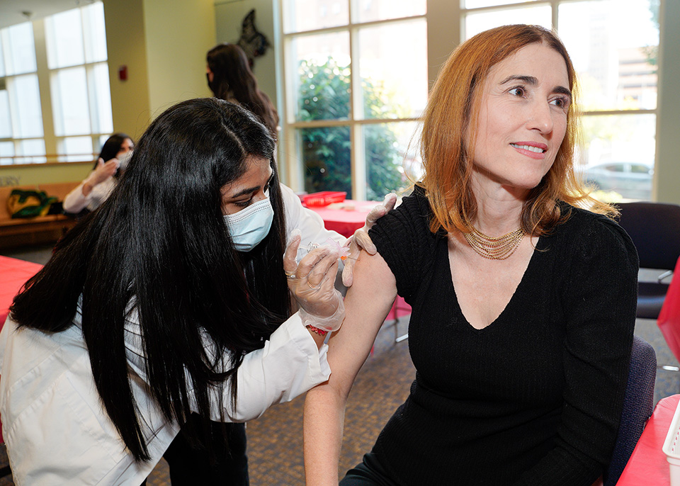 Sarah Michel receives a vaccination from a student pharmacist.